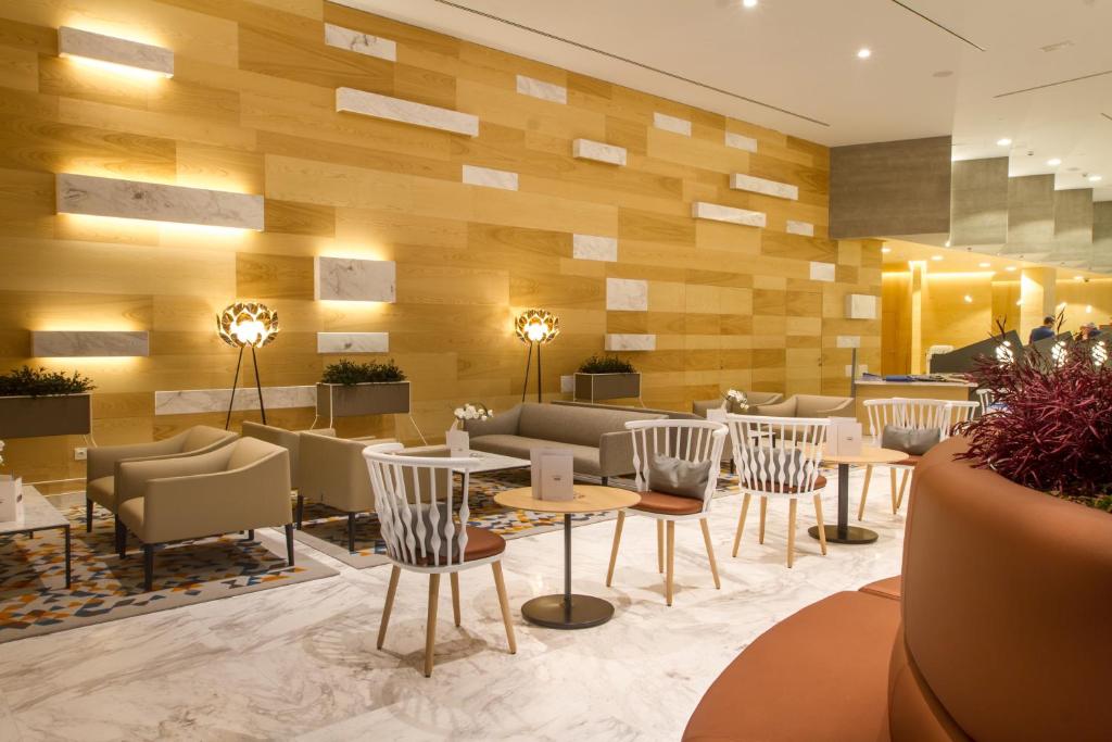 a restaurant with tables and chairs in a lobby at ESTIMAR Calpe Suitopia in Calpe