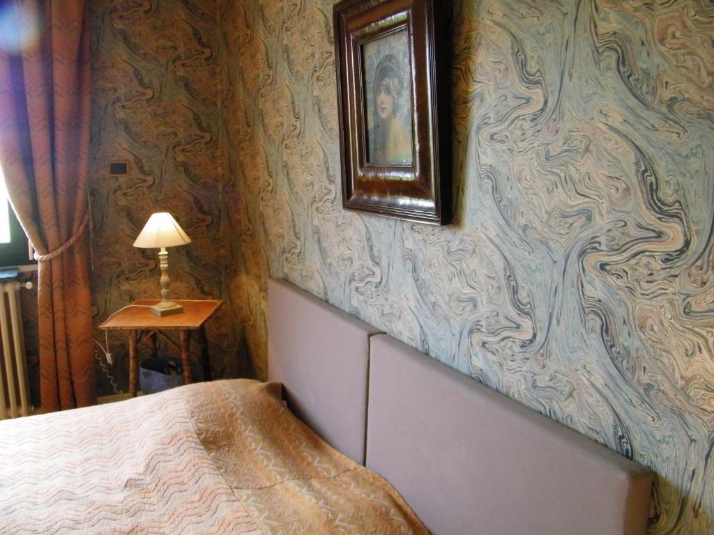 a bedroom with a bed and a picture on the wall at Chambre d'hotes La Jaunais in Virey