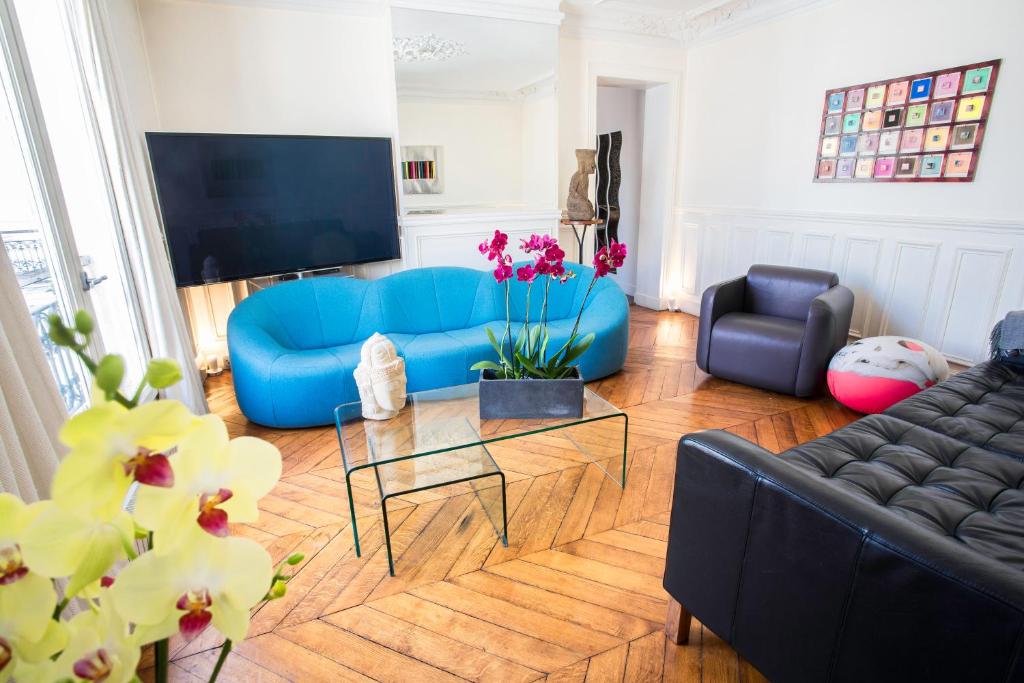 uma sala de estar com um sofá azul e uma mesa em Luxury Apartment in Paris Center - Louvre Museum em Paris