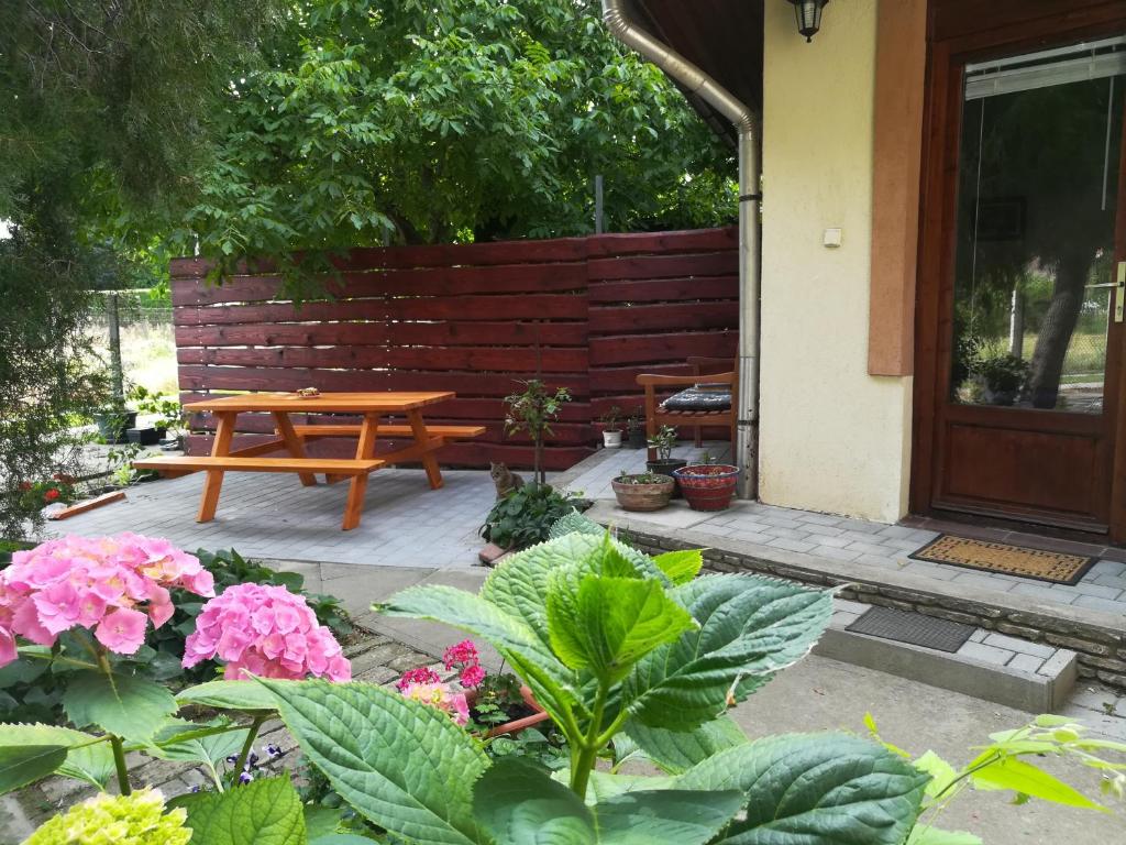 um pátio com uma mesa de piquenique em madeira e flores em Vargapartman em Szeged
