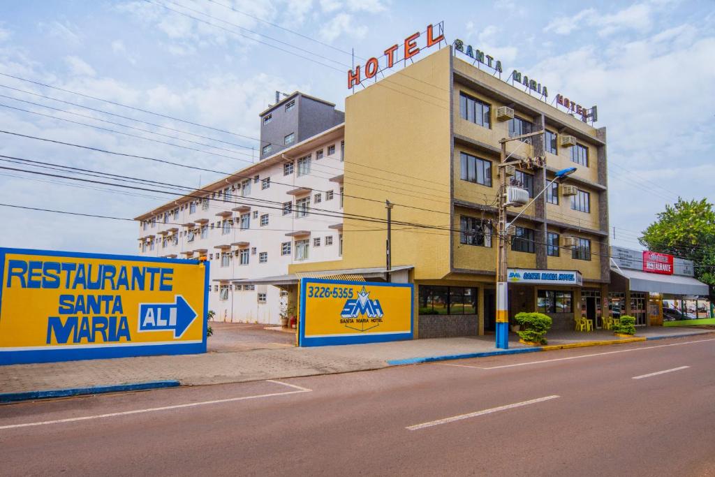 a building on the side of a street with signs at Santa Maria Hotel in Cascavel