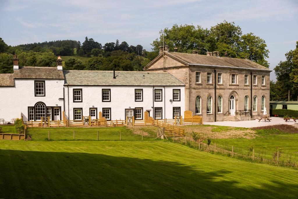a large building with a green field in front of it at Waterfoot Park in Pooley Bridge
