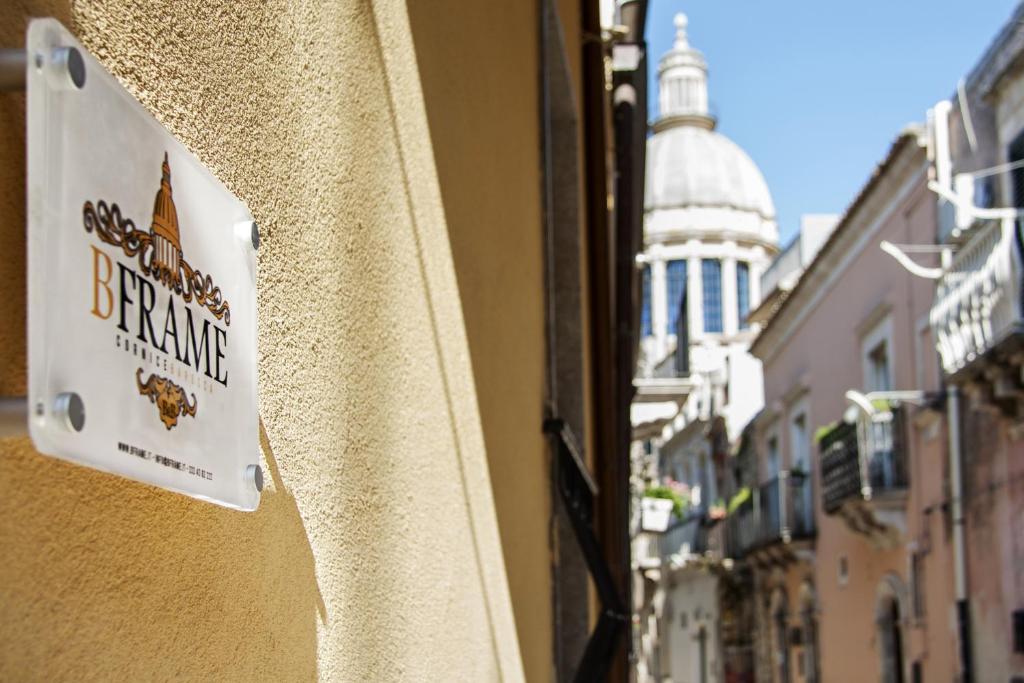 un cartello sul lato di un edificio in una strada di BFRAME Cornice Barocca a Ragusa