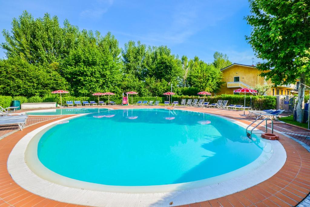 a large swimming pool with chairs and umbrellas at Hotel Riel in Sirmione