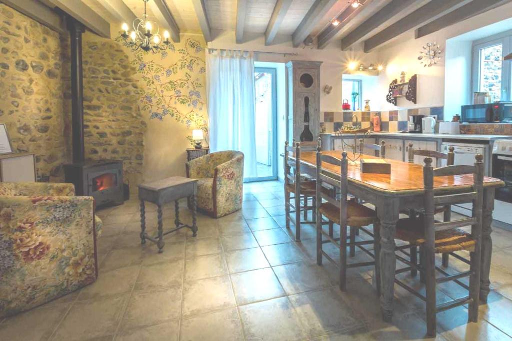une cuisine avec une table et des chaises ainsi qu'une cheminée dans l'établissement La Champillaumiere, à Champeix