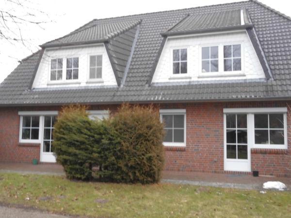 uma casa de tijolos vermelhos com telhado cinzento em Ferienhof-Kirschenholz em Schillsdorf