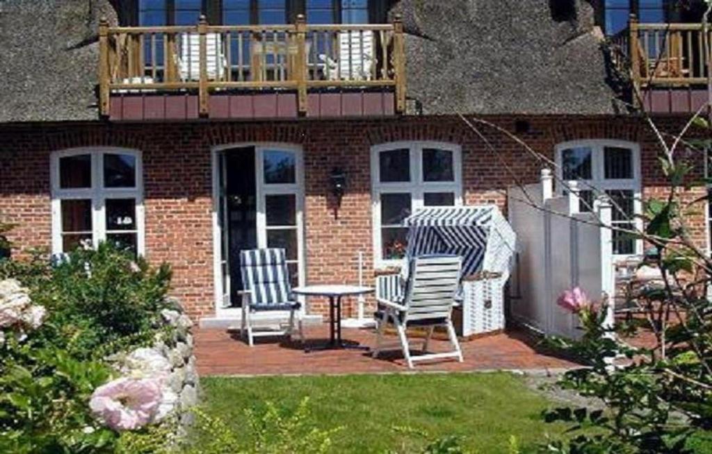 eine Terrasse mit 2 Stühlen, einem Tisch und einem Balkon in der Unterkunft Bi de Kark in Sankt Peter-Ording