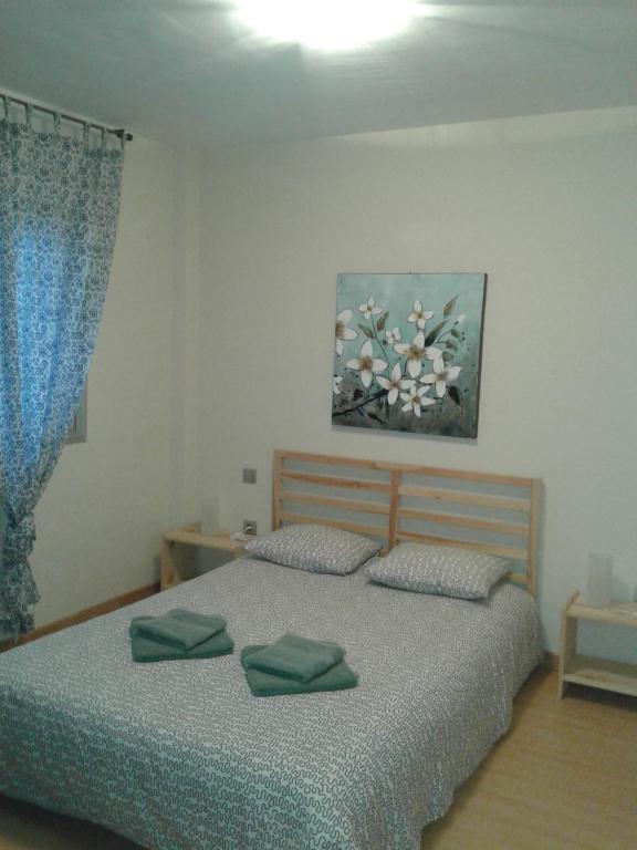 1 dormitorio con 1 cama con 2 almohadas verdes en Apartamentos EOS, en Buzanada