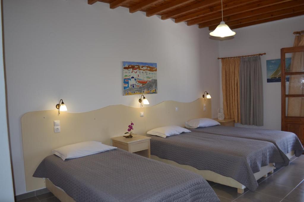 two beds in a hotel room with two beds at Studios Flora Manos in Platis Gialos