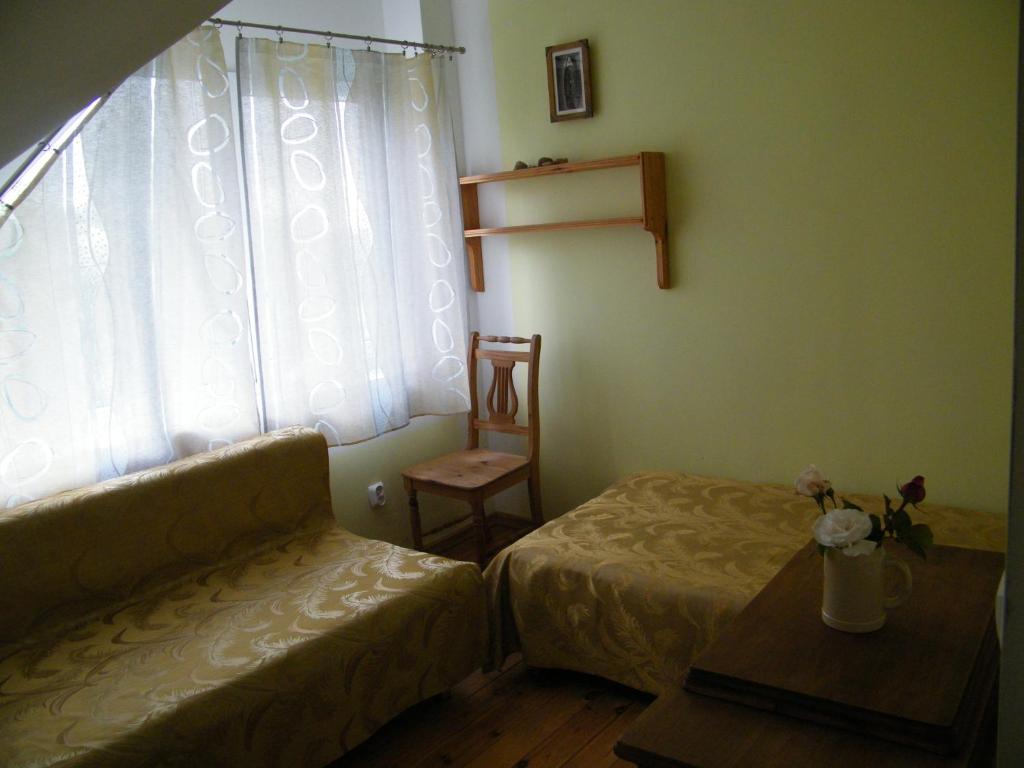 a living room with a couch and a chair and a window at Viesu nams Jūras Bura in Tūja