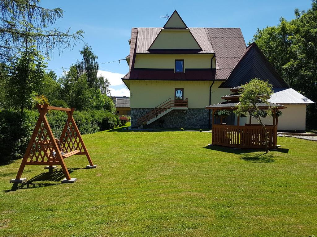 a house with a playground in front of a yard at Hawrań in Białka Tatrzańska