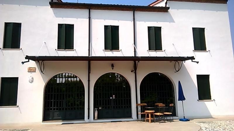 un edificio blanco con dos puertas y una mesa en Villa Gaudio, en Ponte San Nicolo