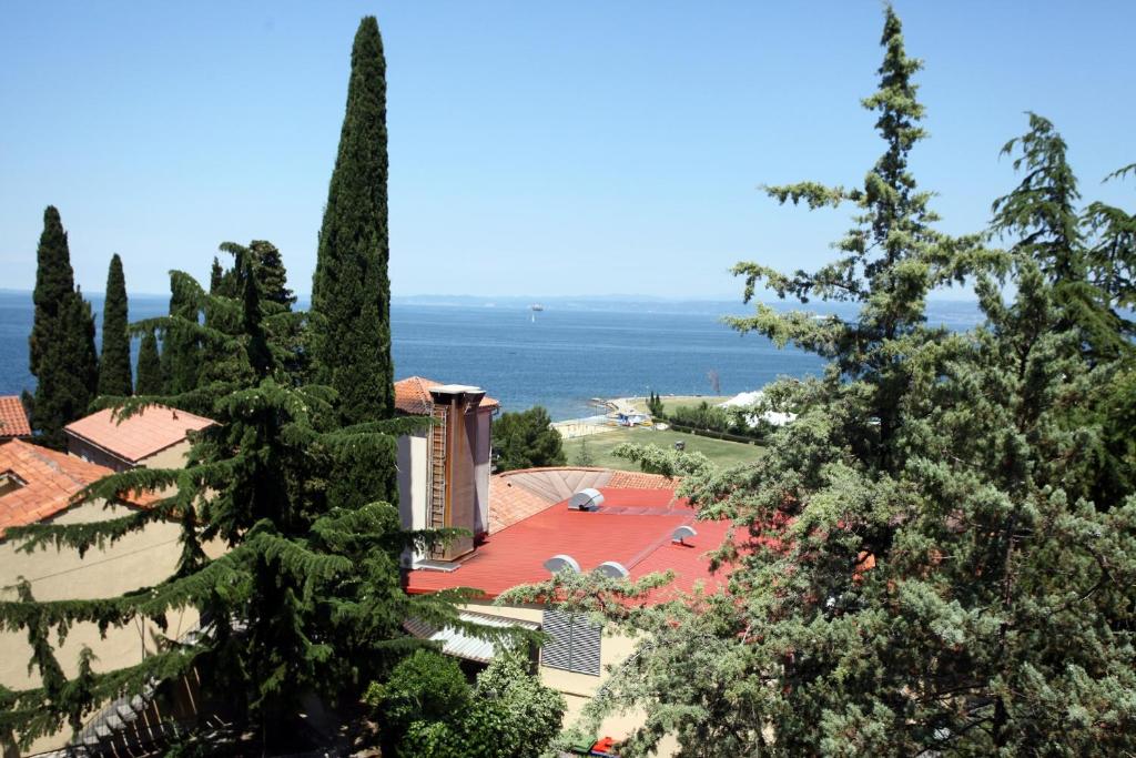 a view of a house with trees and the ocean at Apartma San Simon s pogledom na morje - San Simon Sea View Apartment LL in Izola