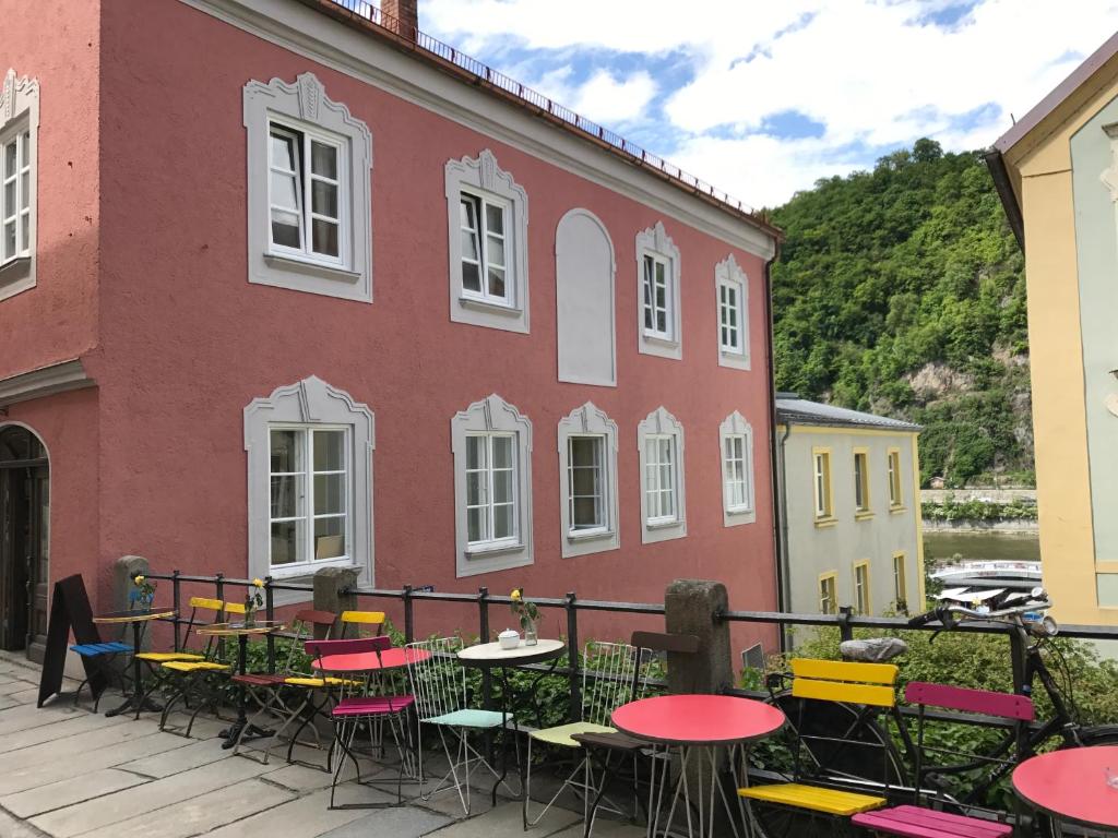 un grupo de mesas y sillas frente a un edificio en das-hornsteiner, en Passau