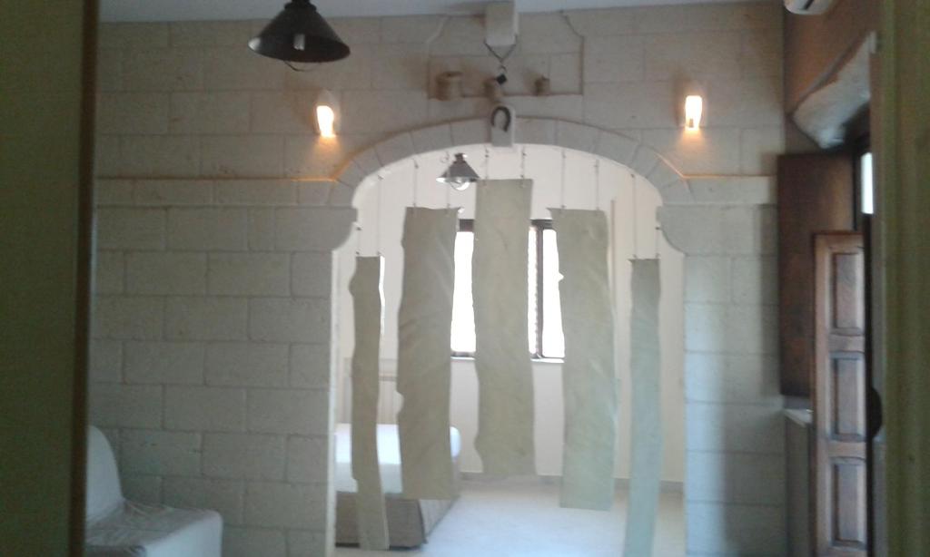 una habitación con un arco con columnas en la pared en Lama Cupa, en Fasano