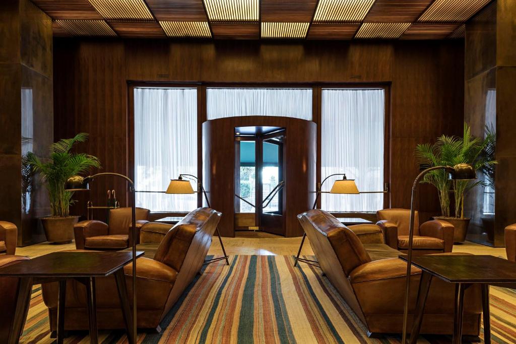 a waiting room with chairs and tables and windows at Hotel Fasano São Paulo Jardins in São Paulo