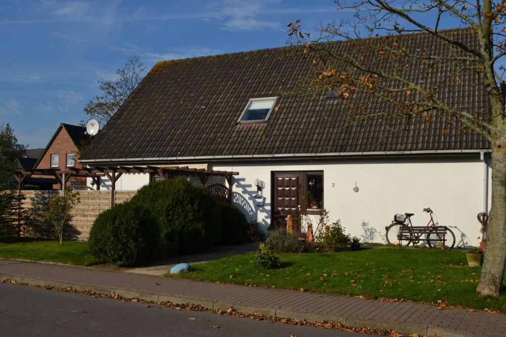 ein weißes Haus mit einem davor geparkt in der Unterkunft Gästehaus Andresen in Garding