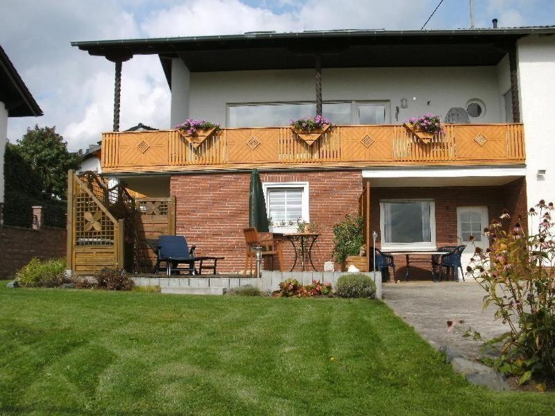 Casa con balcón con mesa y sillas en Ferienwohnung-Nuerburgblick, en Reifferscheid