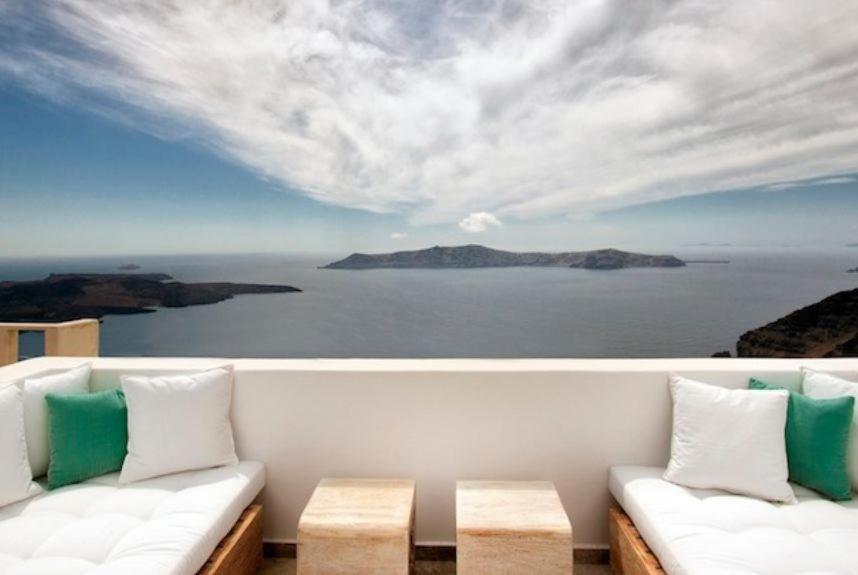 a white couch with a view of the ocean at Allure Suites in Firostefani