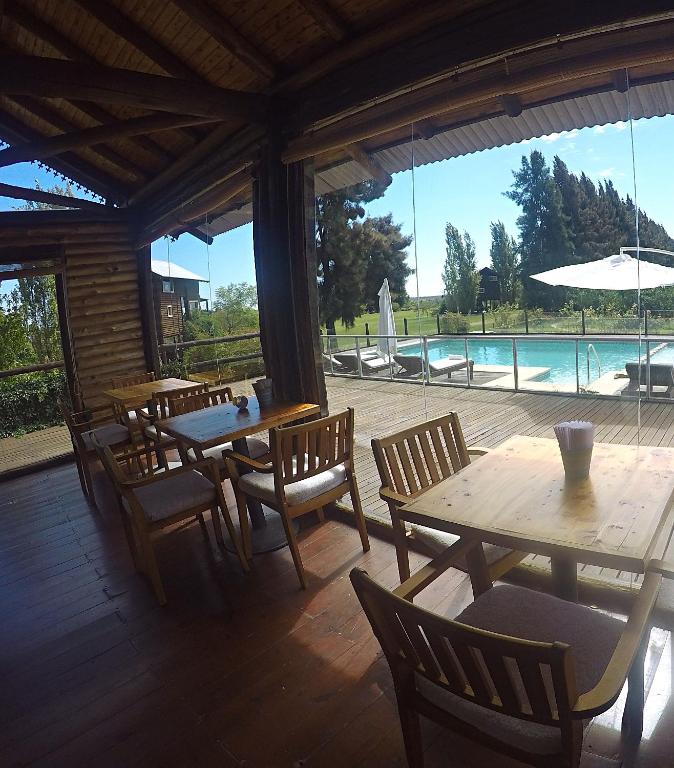 a patio with wooden tables and chairs and a pool at Cabanas del Bajo Hondo in San Pedro