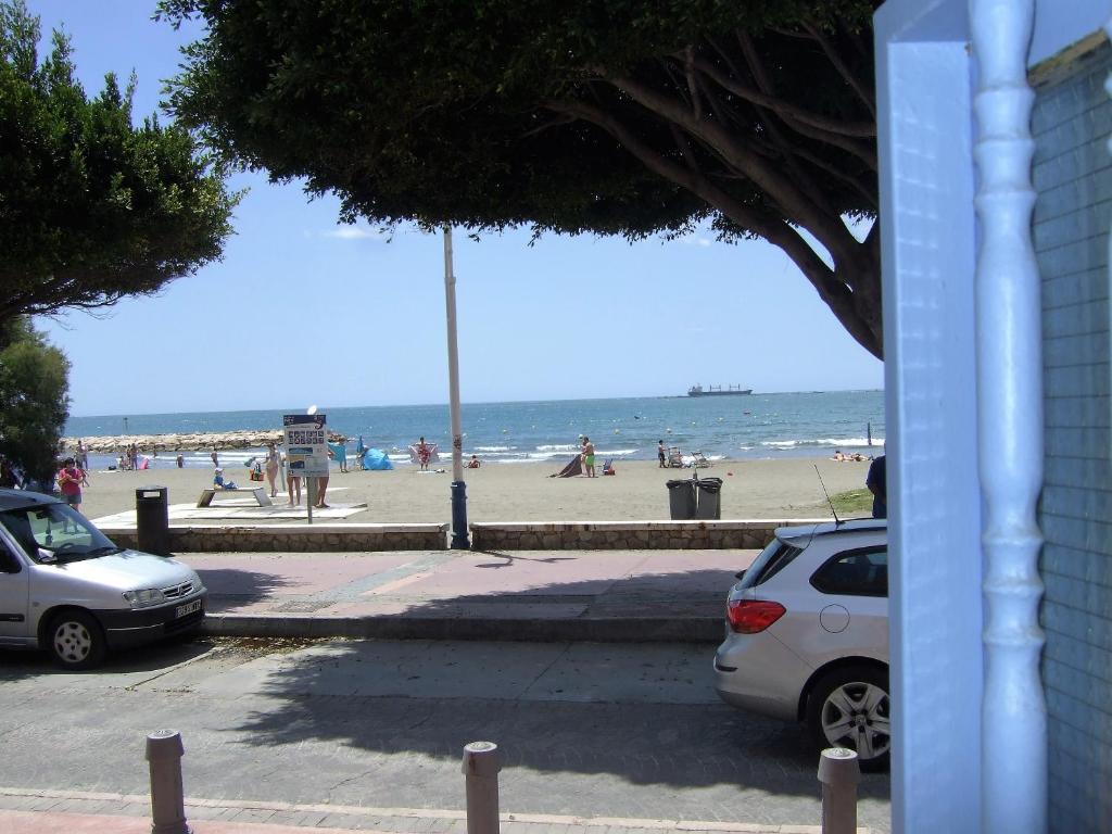 two cars parked next to a beach with the ocean at Apartment on the beach in Málaga