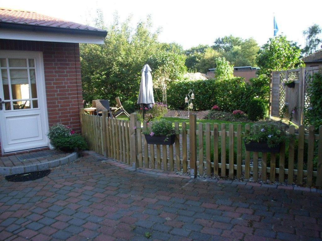 a wooden fence with an umbrella in a backyard at Ferienwohnung-Abendroete in Lüdersburg