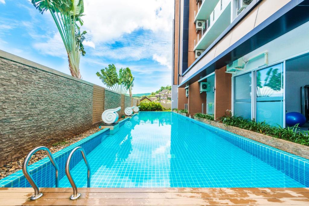 a swimming pool in front of a building at Karon Chic Studio by Rent Angel in Karon Beach