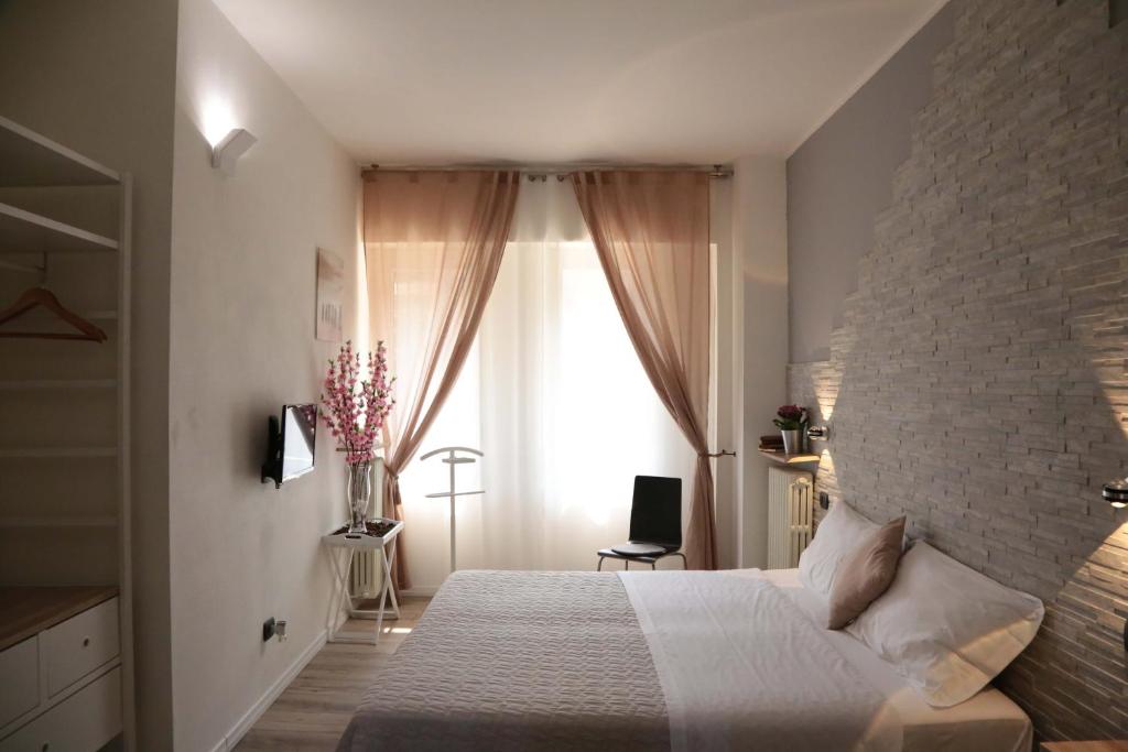 a bedroom with a white bed and a brick wall at Aurelia Rooms in Verona