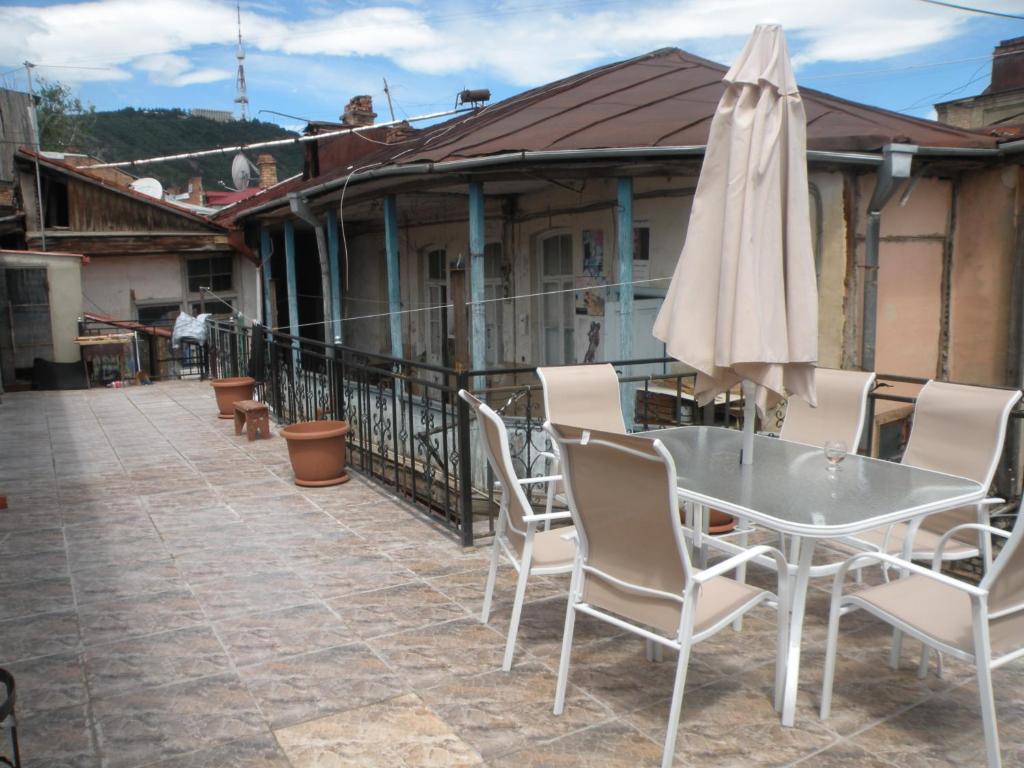 a patio with a table and a white umbrella at Guest House Nice in Tbilisi City