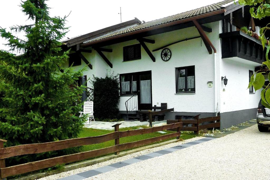 a white house with a wooden fence in front of it at Haus-Monika-am-Chiemsee in Übersee