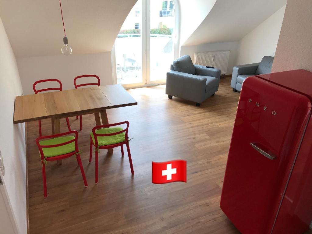 uma sala de estar com um frigorífico vermelho e uma mesa e cadeiras em SWISS LOFT by Europa-Park - EP Ticket Garantie em Rust