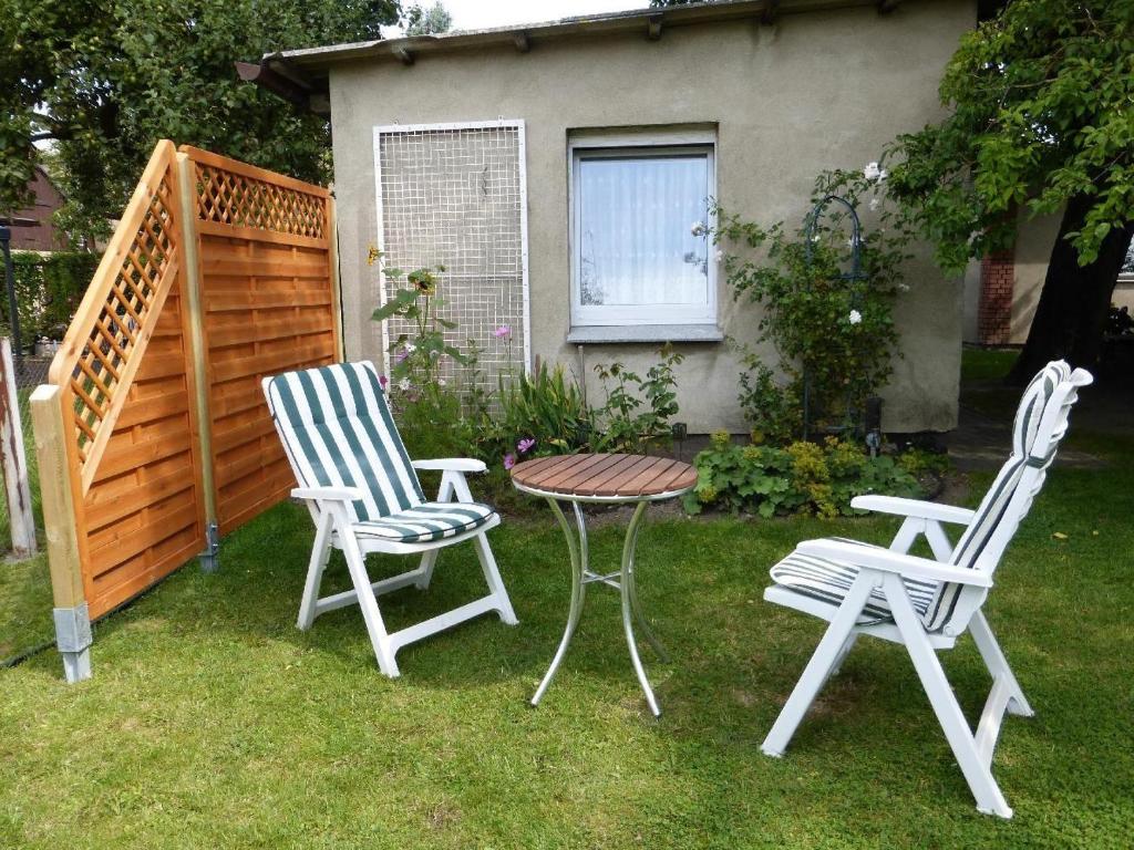 zwei Stühle und ein Tisch und zwei Stühle in einem Hof in der Unterkunft Ferien-Apartment mit Gartenblick in Rostock