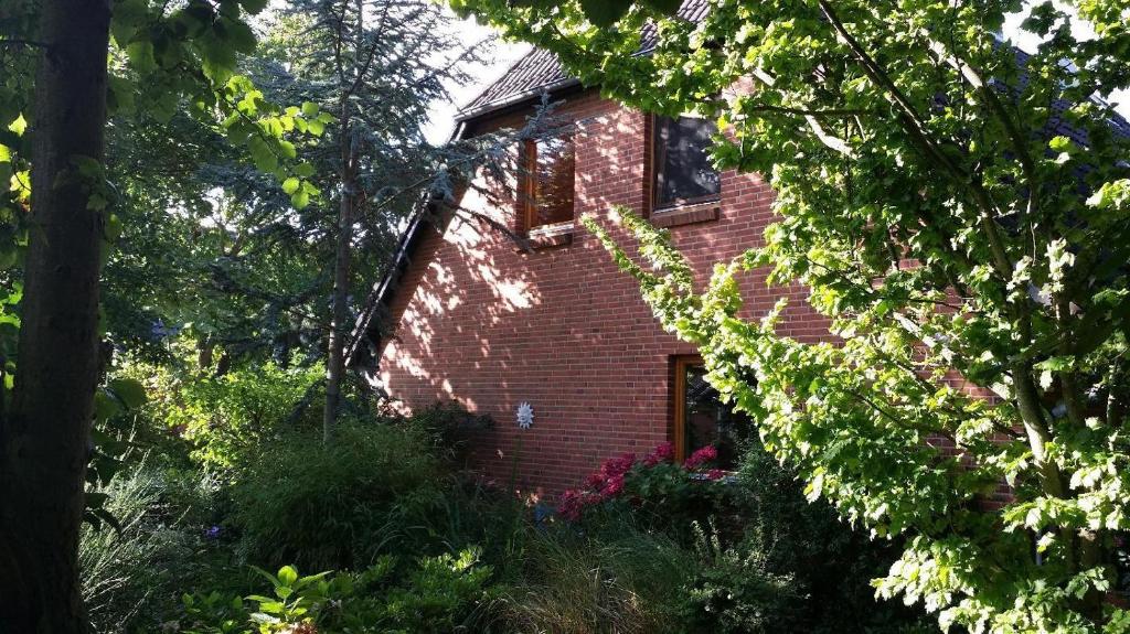 a red brick house with a window and trees at Haus-Marla in Tating