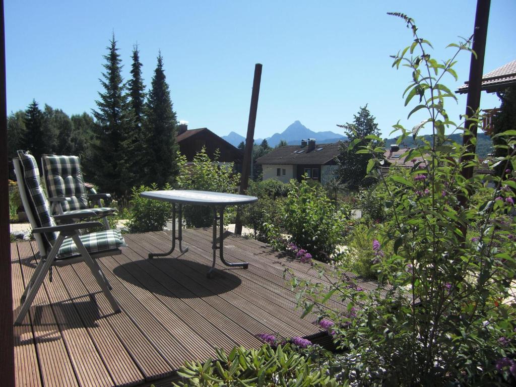 eine Holzterrasse mit einem Tisch und einem Stuhl in der Unterkunft Apart Studio am Rosengarten in Füssen