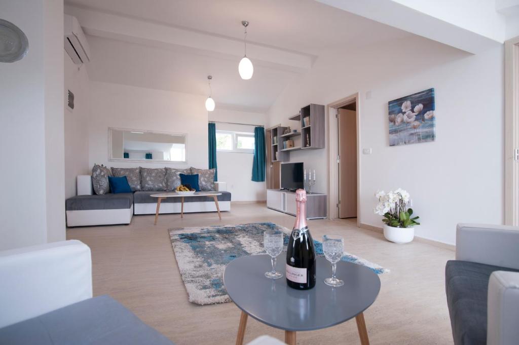 a living room with a bottle of wine on a table at Apartments Kuljace in Sveti Stefan