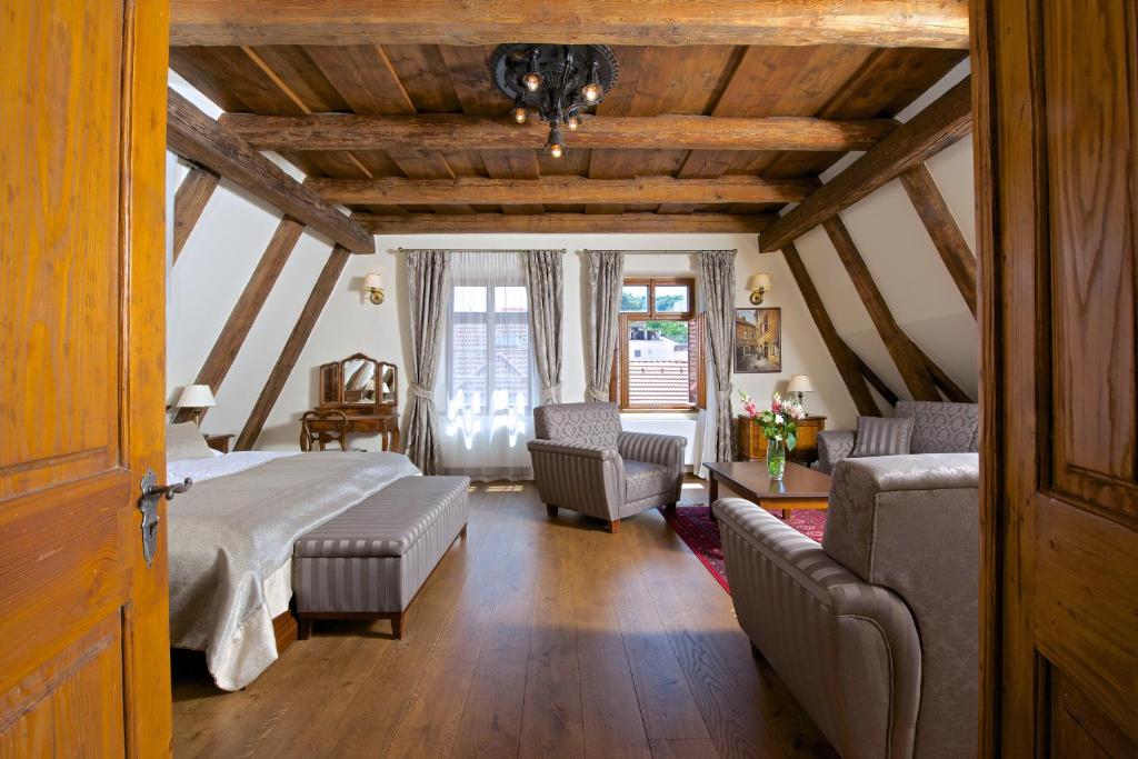 ein Schlafzimmer mit einem Bett, einem Sofa und Stühlen in der Unterkunft Residence U Mecenáše in Prag