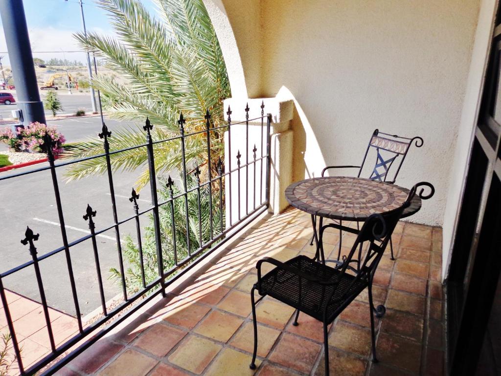 a table and chair on a balcony with a view of a street at Ramada by Wyndham Las Cruces Hotel & Conference Center in Las Cruces