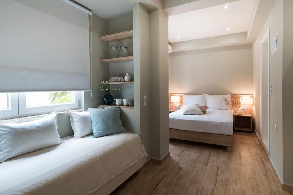 a bedroom with two beds and a window at Riaki Apts in Malia