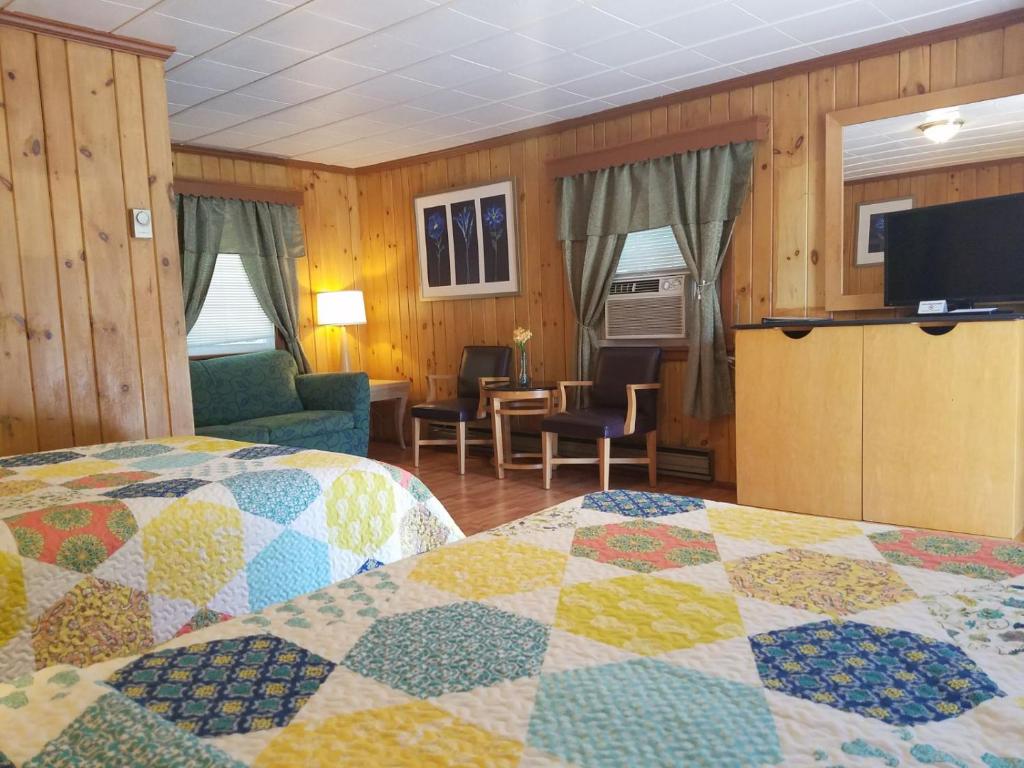 a hotel room with two beds and a tv at Seven Dwarfs Cabins - Brown Cabins in Lake George