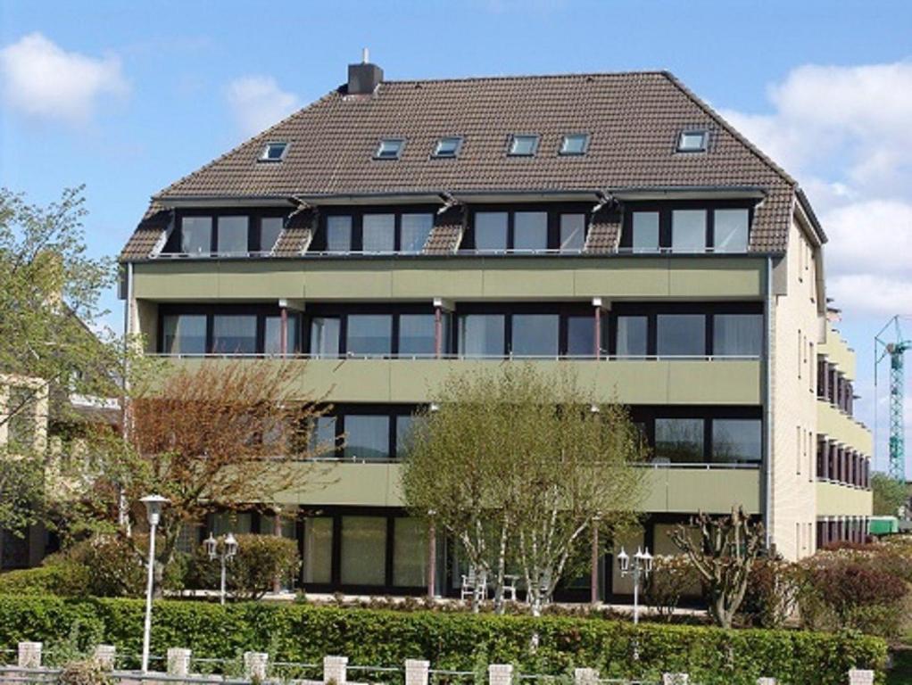 ビューズムにあるStrandresidenz-Rosengarten-Wohnung-Nr-108の茶色の屋根の大きなアパートメントビル