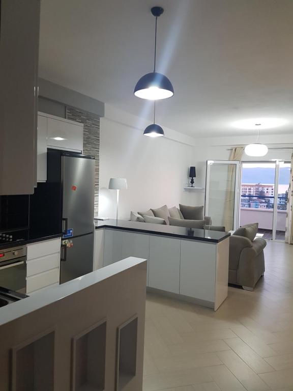 cocina y sala de estar con sofá y nevera en Modern cozy apartment seaview en Vlorë