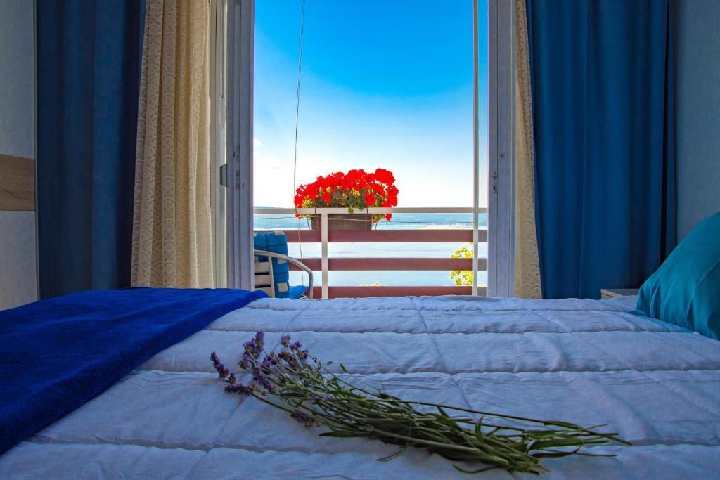 a bedroom with a bed with a view of the ocean at Guest House Djurdjica in Dramalj