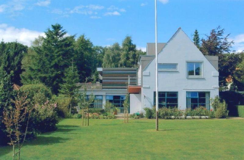 una gran casa blanca en un patio con árboles en Haus-Muehlenpark en Wyk auf Föhr