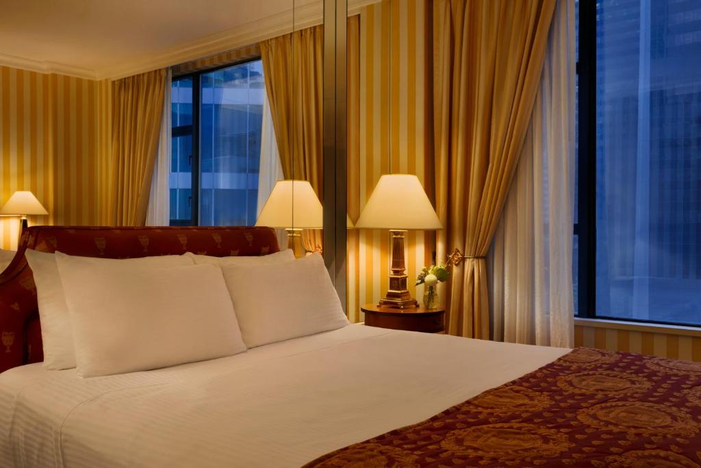 a bedroom with a bed and a large window at Hotel Le Soleil by Executive Hotels in Vancouver