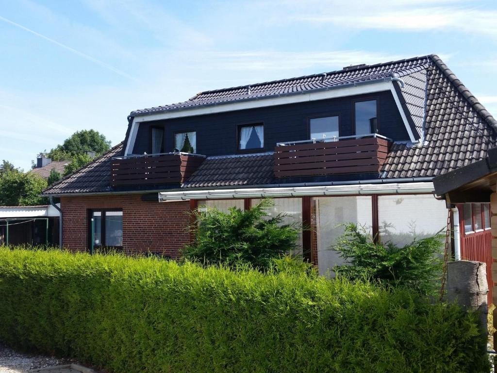 a house with a gambrel roof with a balcony at Haus Lily Nr.02 bis zu 6 Personen davon max. 2 Kinder in Büsum