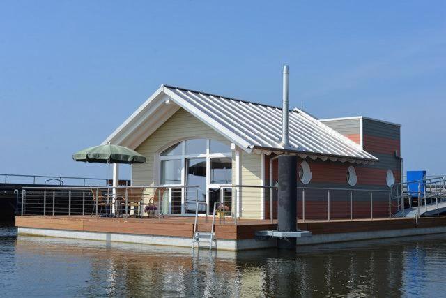 ein kleines Haus auf einer Anlegestelle am Wasser in der Unterkunft "Hiddensee" in Wiek auf Rügen 