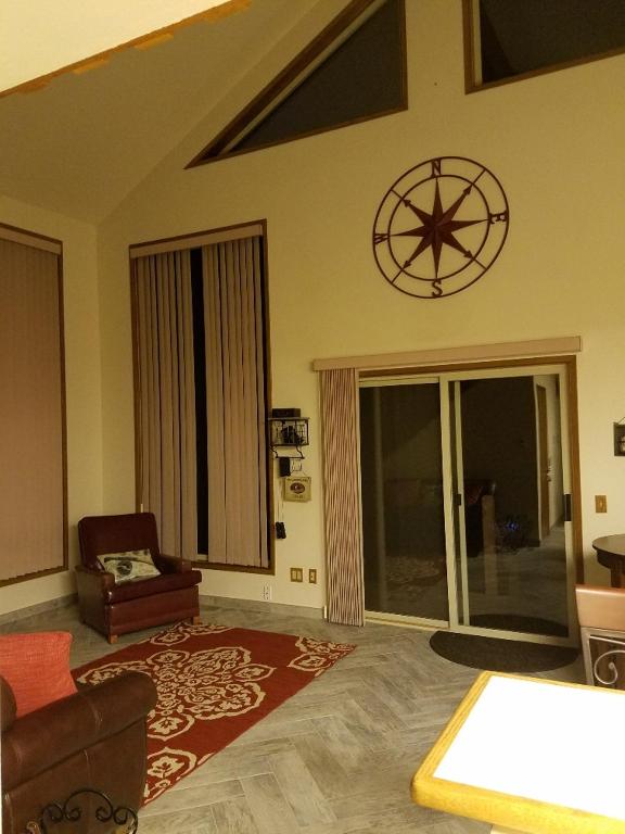 a living room with a chair and a clock on the wall at A Relaxing Getaway SolDuc 1 in Forks