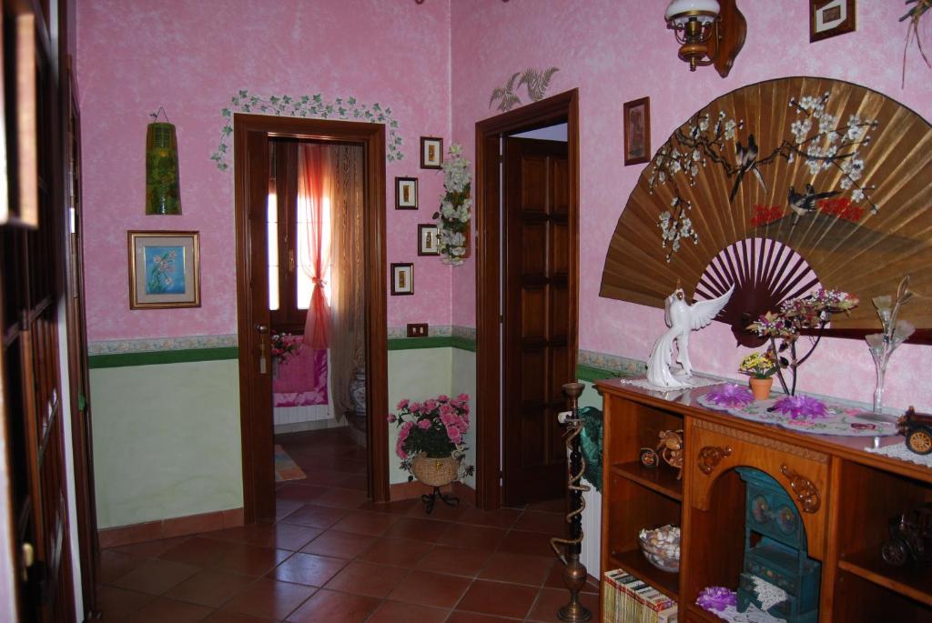 a room with a pink wall with a mirror at Sette Nani in Elmas