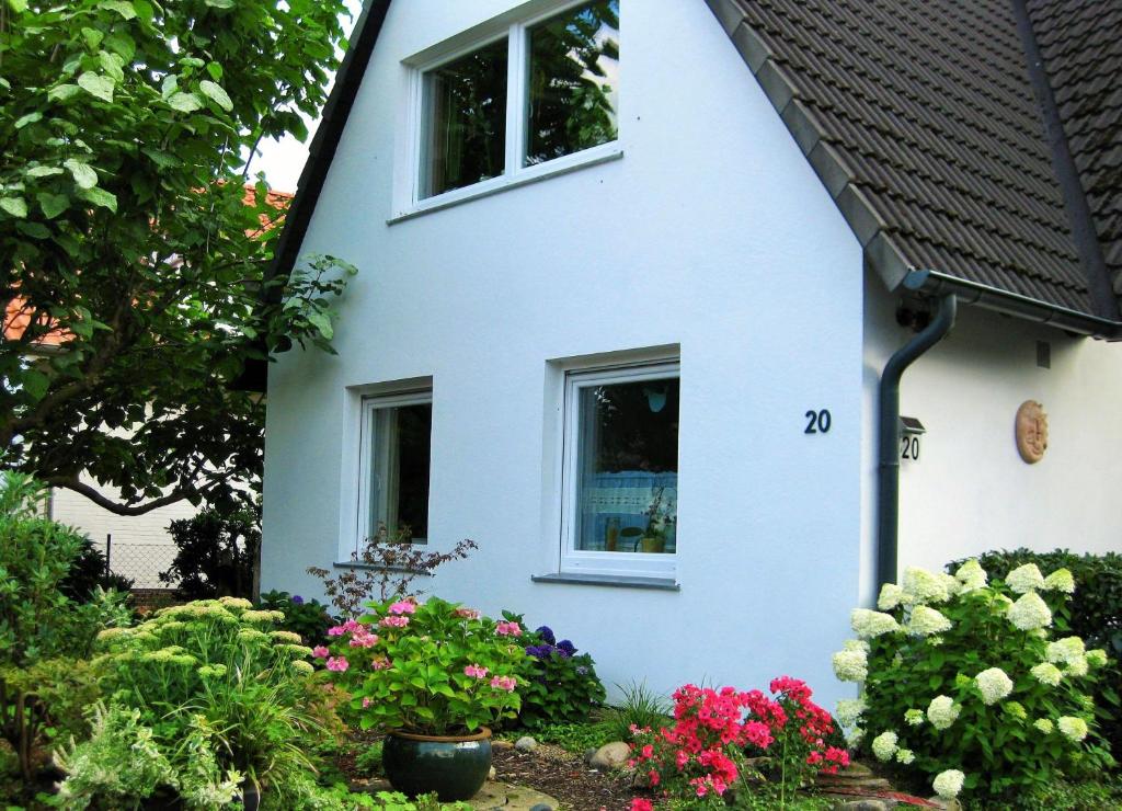 ein weißes Haus mit Blumen davor in der Unterkunft Gästezimmer in Rotenburg in Rotenburg an der Wümme