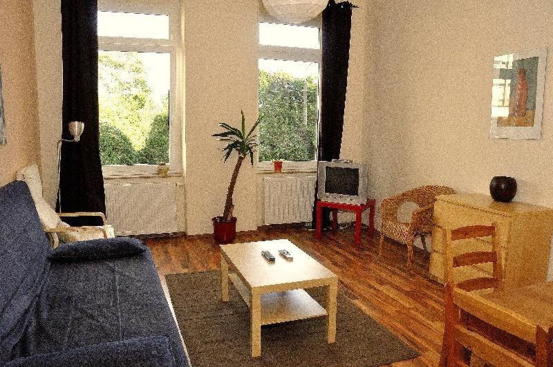 ein Wohnzimmer mit einem blauen Sofa und einem Tisch in der Unterkunft Fewo Dresden Neustadt - zentral & preiswert L5 in Dresden